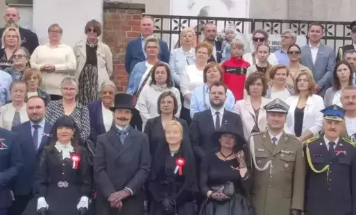 Uczestnicu powtórnego pochówku pozują do wspólnego pamiątkowego zdjęcia.