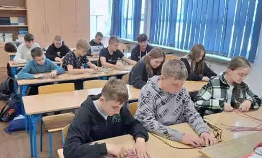 Uczniowie tworzą makramowe podkładki.